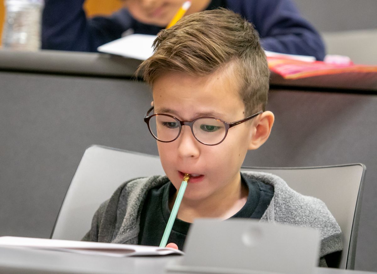 Math Olympiad participant biting on a pencil while reviewing the exam