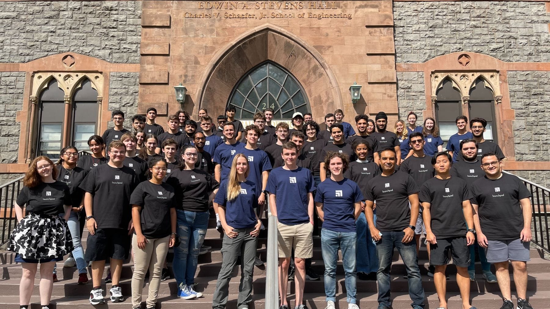 Group of Launchpad students and mentor pose on the steps of the Edwin A. Stevens Building