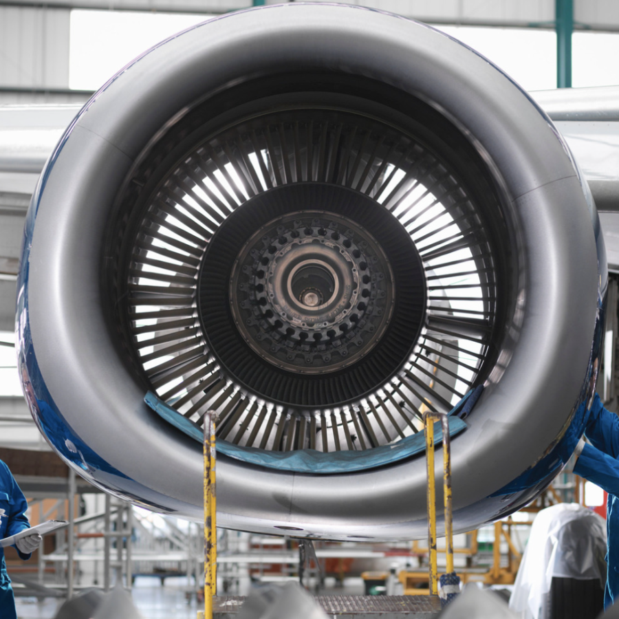 Aircraft engineers working on a 737 jet engine in airport