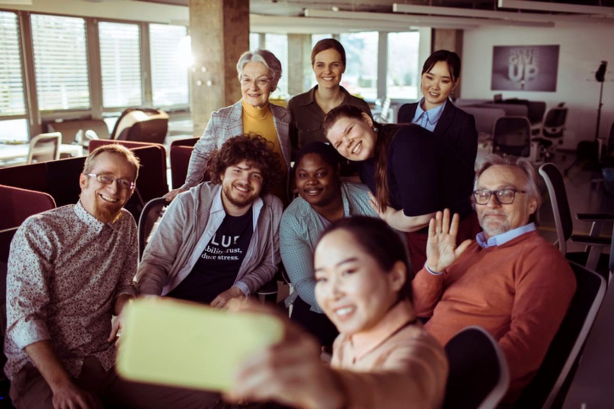 group of coworkers taking a group selfie picture