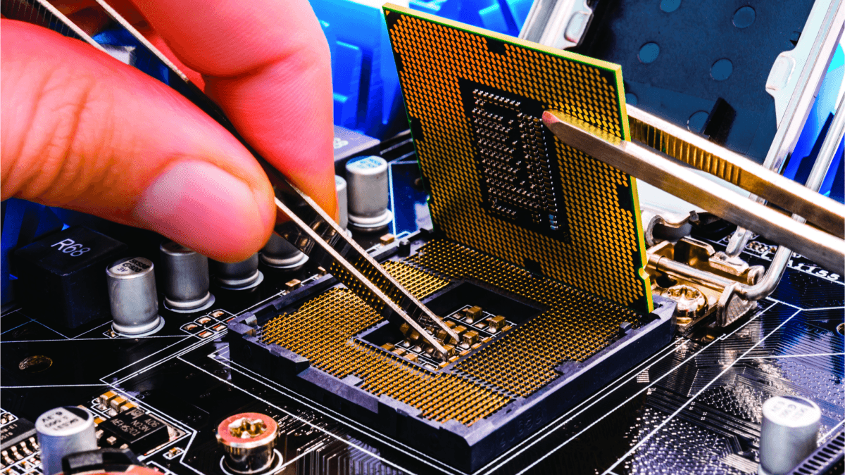 A photo of a thumb and pointer finger holding tweezers, which are tinkering with a computer chip