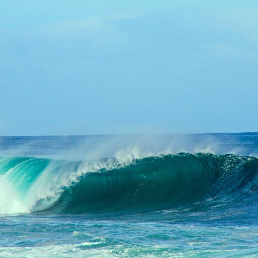 A blue breaking wave in the ocean, representing wave power