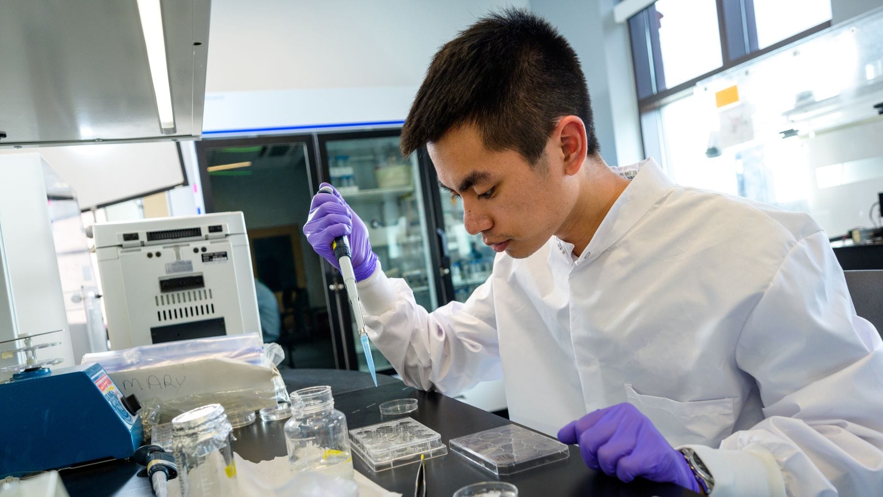 student with pipette in lab