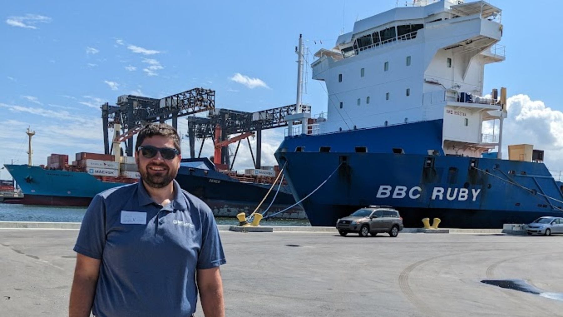 Sean Dirscherl stands in front of a cargo ship