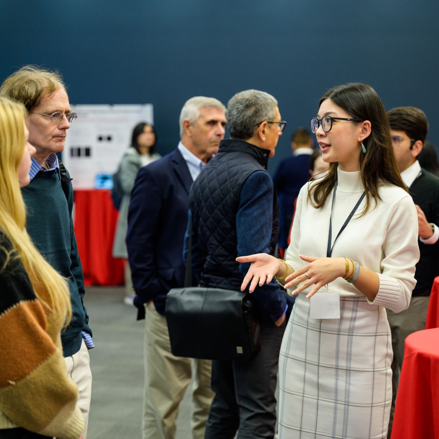 A female student discussing research with attendees at the SIAI Relaunch event