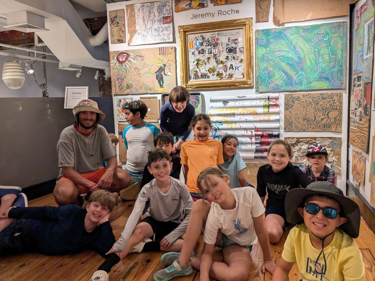 Jeremy Roche appears in front of his artwork at the Hoboken Historical Museum with a group of kids