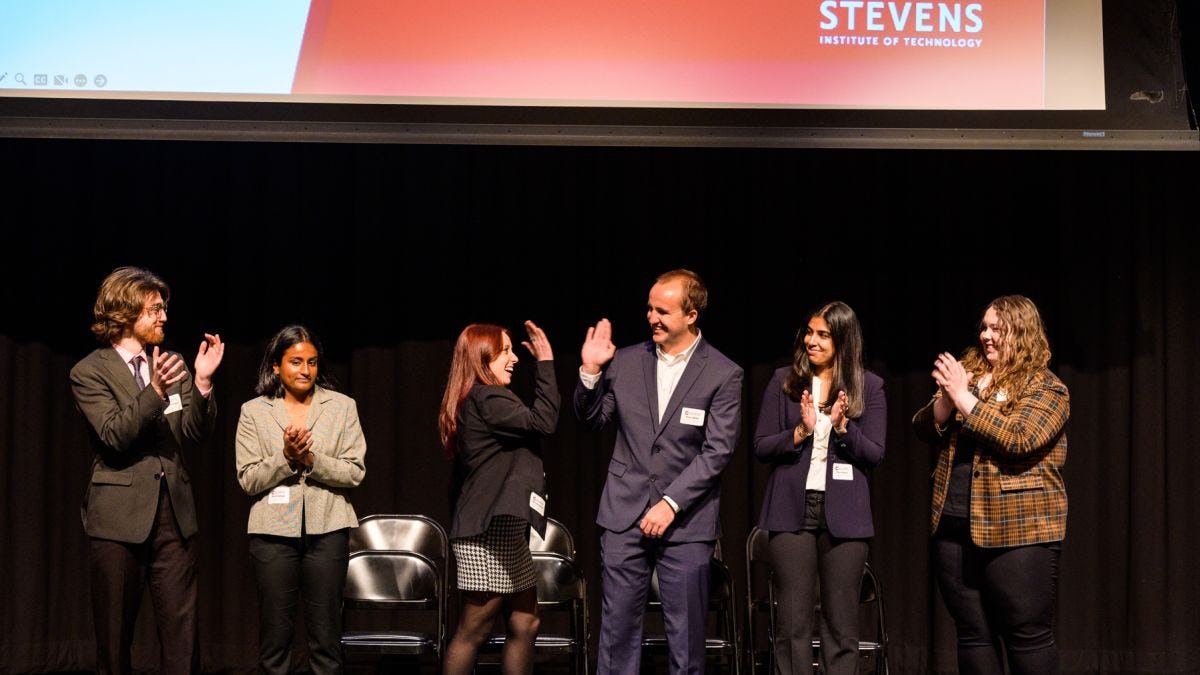 Students celebrate on stage at Innovation Expo