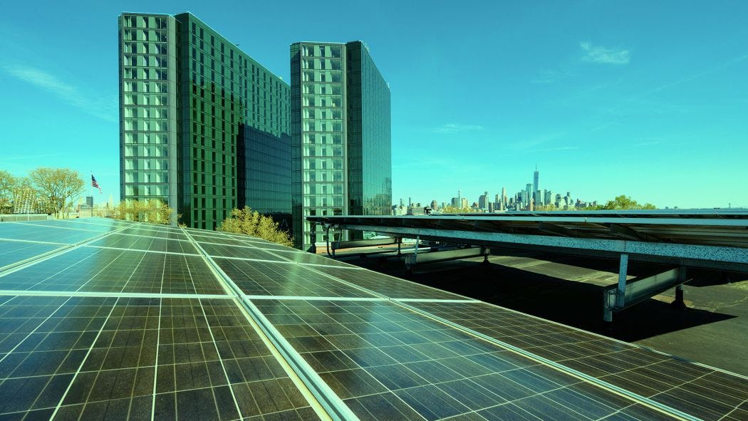 Solar panels on rooftop on Stevens campus, with NYC skyline behind