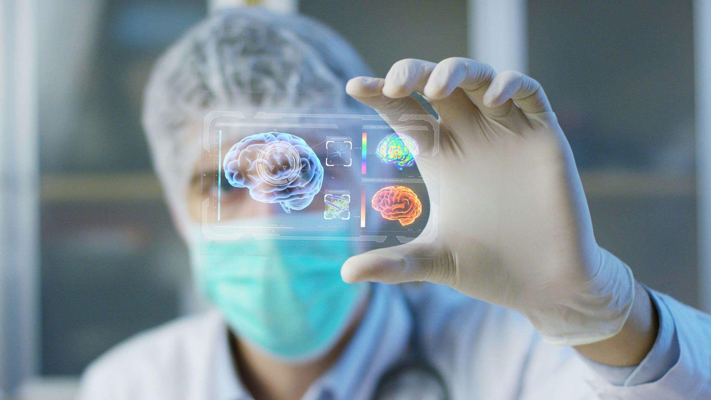 A person wearing medical equipment holding up a high-tech image of the brain