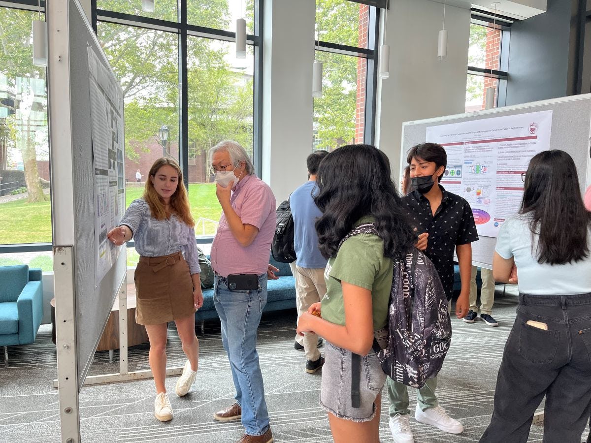 2022 REU student Grace McGraw gives a poster presentation to Kenny Wong