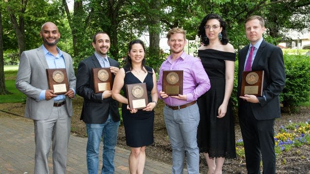 Alumni pose with their award plaques at Alumni Weekend