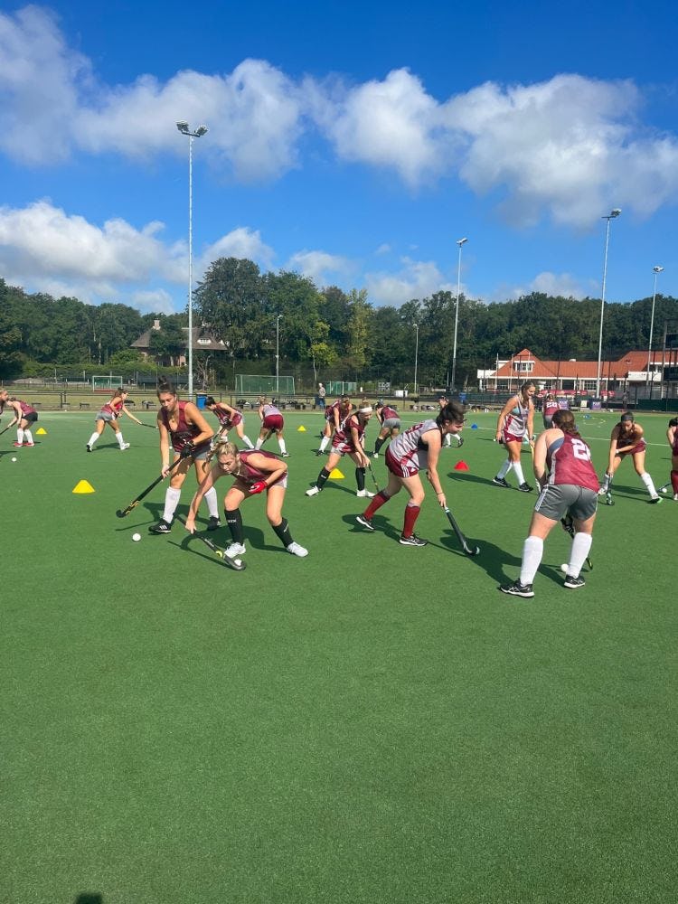Group of Stevens field hockey players practice on the field during their summer 2023 trip