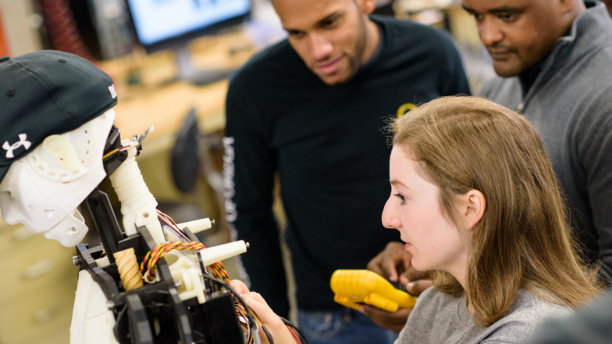 A photo of Stevens students working on a robot in a mechanical engineering lab.